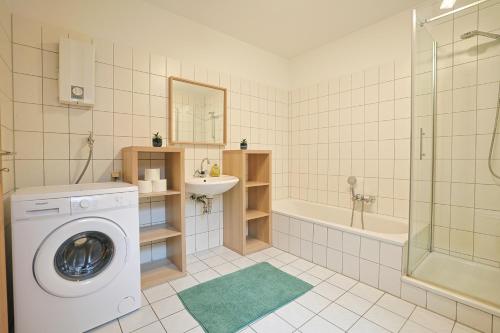 Ferienwohnung in Lohfelden nahe Kassel في لوهْفيلدِن: حمام مع غسالة وحوض استحمام