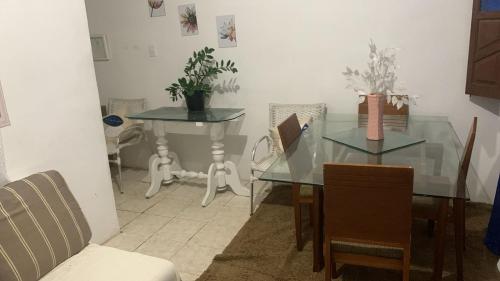 a dining room with a glass table and chairs at Casa Pousadinha Mel in Salvador