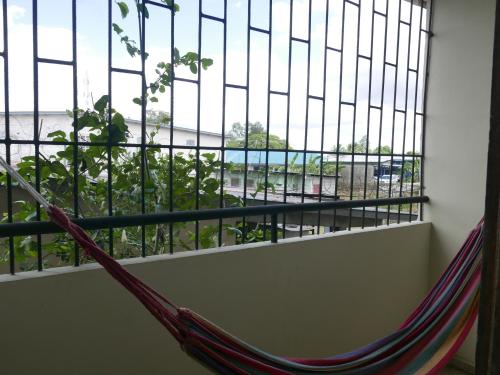 a hammock in a room with a large window at Apart-hotel alessia in Santiago