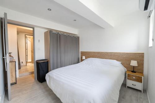 une chambre avec un lit blanc et un parquet dans l'établissement Darja, à Carcassonne