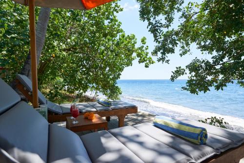 a view of the beach with a couch and a table at Octopus Villas in Tejakula