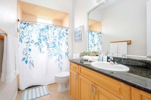 ein Badezimmer mit Waschbecken, Toilette und Duschvorhang in der Unterkunft Palm Pointe - Waterfront Vacation Rental Cape Cora in Matlacha