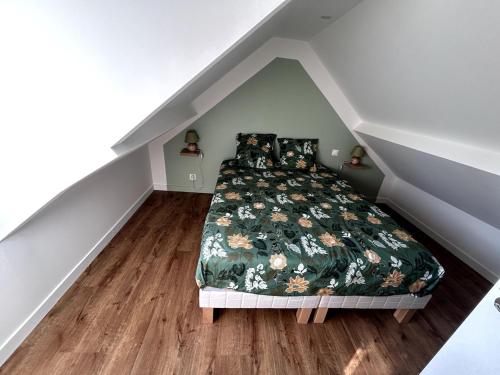 Un dormitorio con una cama con una colcha floral. en Le Sillage Vert, en Rosnoën