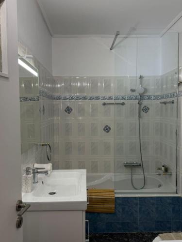 Un baño con ducha, lavabo y bañera. en Boho Coastal Retreat with Jacuzzi, 1 min to Beach, en Atenas