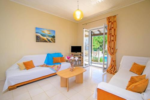 ein Wohnzimmer mit zwei weißen Sofas und einem Tisch in der Unterkunft Villa Marias Beach House by Villa Plus in Ágios Stéfanos
