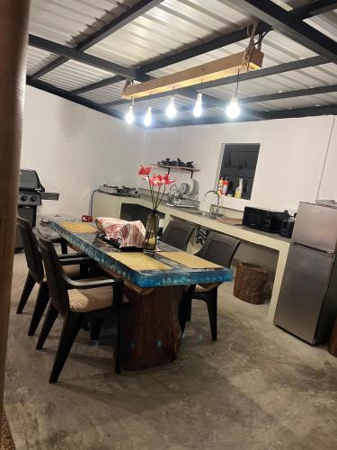 una cocina con una mesa con sillas y una cocina con refrigerador en Palmiste Villa, en Mare dʼAlbert
