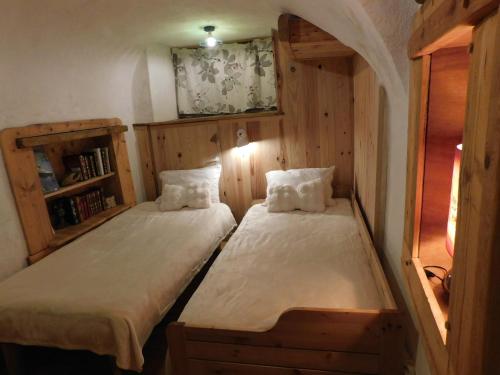 two beds in a small room with wooden walls at Petite maison de village cosy à Serre chevalier in Le Monêtier-les-Bains