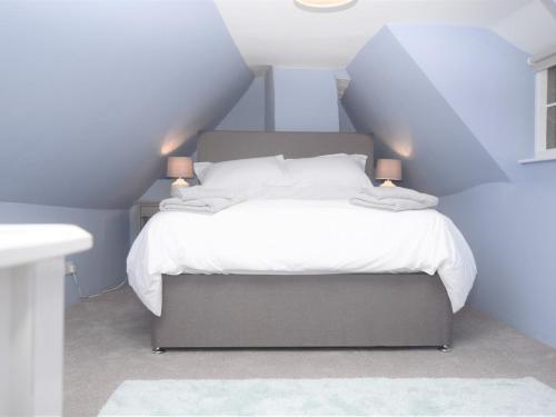 una camera da letto con un letto con lenzuola e cuscini bianchi di 2 Bed in Wroxham 56104 a Hoveton