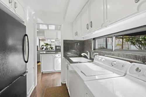 eine Küche mit Waschmaschine und Trockner in der Unterkunft Iconic 4Br Bayfront Home W Unmatched Indooroutdoor Living By Beachview Rentals in Newport Beach