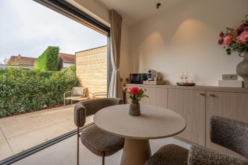 a room with a table and chairs and a balcony at Luxe Guestroom free bikes and parking in Bruges