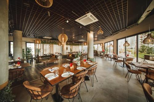 ein Restaurant mit Holztischen und -stühlen und Fenstern in der Unterkunft Luxurious Apartment with Pool View at Caesar Resort Am32 in Perivolia tou Trikomou