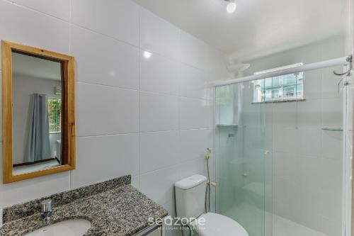 a bathroom with a toilet and a sink and a mirror at Apto 2 Quartos a 200 m da Praia MAO0203 in Cururupe