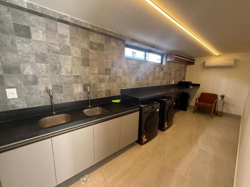 a kitchen with two sinks and a counter with a washer at 105 Dutra Ocean Flat - Take Home in Tambaú