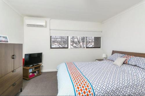 une chambre avec un lit et une télévision à écran plat dans l'établissement Modern 2BR Apartment North Adelaide, à North Adelaide