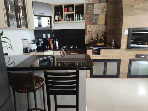 ペーニャにあるFamily houseのカウンターとスツール付きのバーのあるキッチン