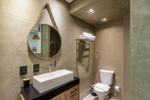 a bathroom with a sink and a toilet and a mirror at RD Cyclinn Vila Olímpia in Sao Paulo
