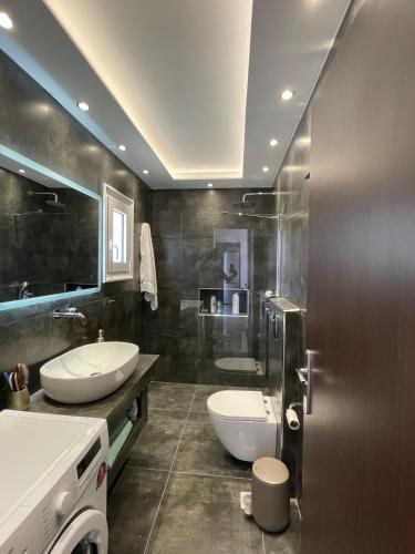 a bathroom with two sinks and a toilet at Casa del Rey in Piraeus