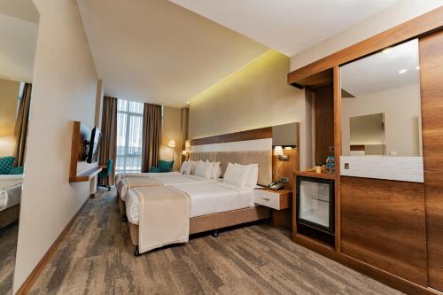 a hotel room with a large bed and a television at Charma Luxury Hotel by Puriffs in Safranbolu