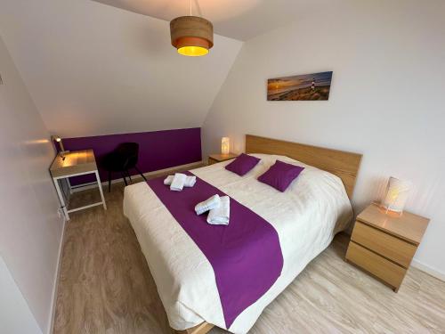 a bedroom with a large bed with two towels on it at KER EOZEN - Maison confortable en plein centre in Plouguerneau