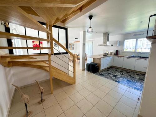 a room with a loft bed and a kitchen at KER EOZEN - Maison confortable en plein centre in Plouguerneau