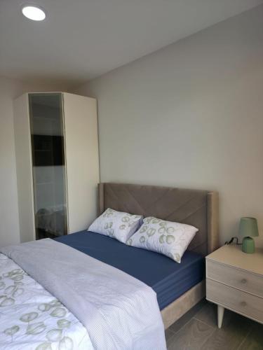 弗利康弗拉克Sea'Amore - Luxury Premium Beach Apartment的一间卧室配有一张床和一个带床头柜的梳妆台