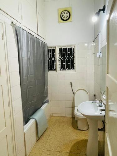 une salle de bains avec douche, toilettes et lavabo dans l'établissement Lovely bedroom in a centrally located apartment, à Maputo