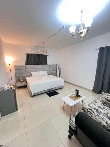 a large bedroom with a bed and a couch at Royale Rooms in Al Ain