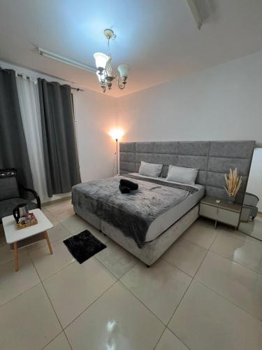 a bedroom with a large bed and a couch at Royale Rooms in Al Ain