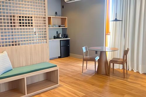 ein Wohnzimmer mit Tisch und Stühlen und eine Küche in der Unterkunft Apartamento com banheira Dupla Vale dos Vinhedos in Garibaldi