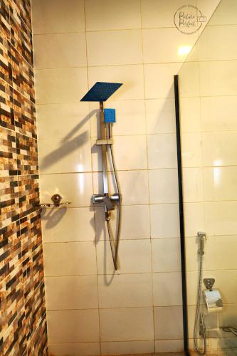 a shower in a bathroom with a tile wall at The Haven Sun N' Fun Hotel in Elephant Island