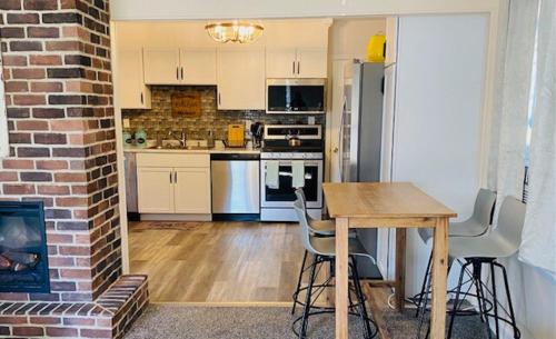 una cucina con tavolo e muro di mattoni di Lake Trail Cottage a Michigan City
