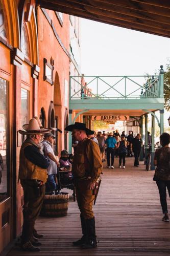 a group of men standing on a street at Settle Into a Cozy Old West Cabin Tent Escape in Tombstone