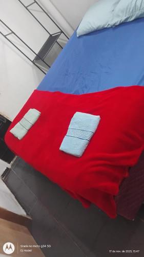 a red blanket on a bed with two napkins on it at Casa Completa 2 Santa Alexandrina in Rio de Janeiro