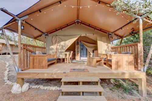 une tente avec une terrasse en bois devant elle dans l'établissement Glamping Getaway on Winery in Hill Country, à Johnson City