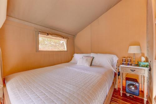 une petite chambre avec un lit et une fenêtre dans l'établissement Glamping Getaway on Winery in Hill Country, à Johnson City