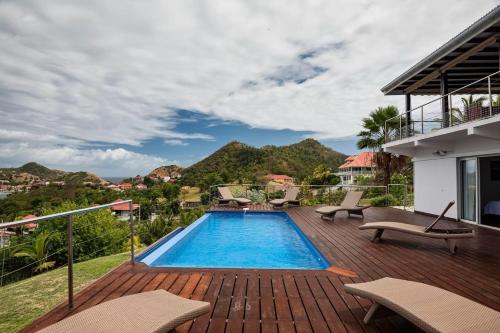 a swimming pool on a deck next to a house at Villa Mangouste in Terre-de-Haut