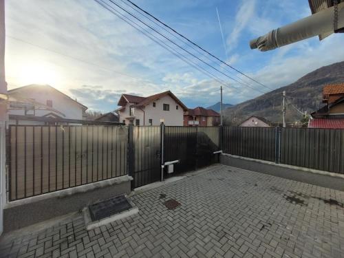 eine Terrasse mit Zaun und ein Gebäude mit Häusern in der Unterkunft Casa Lumi in Petrila