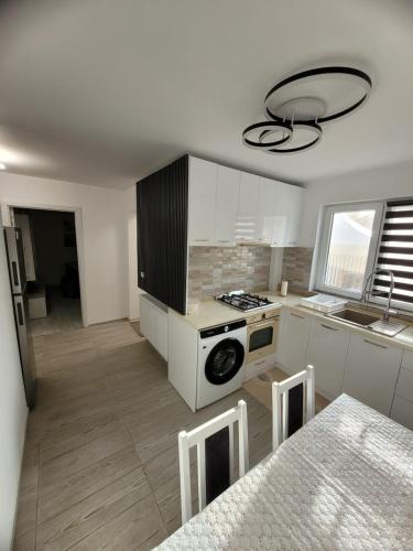 a kitchen with white cabinets and a stove top oven at Casa Lumi in Petrila