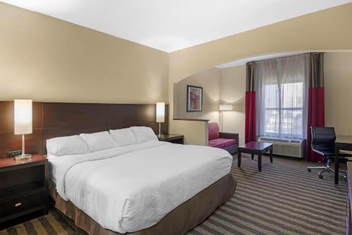a hotel room with a large bed and a desk at Best Western Suites near Opryland in Nashville