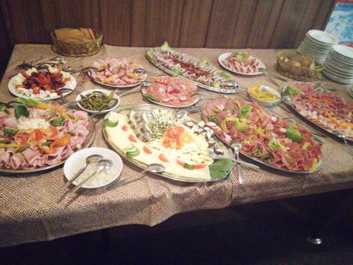 una mesa con muchos platos diferentes de comida en ella en Horská chata Roubenka, en Strážné