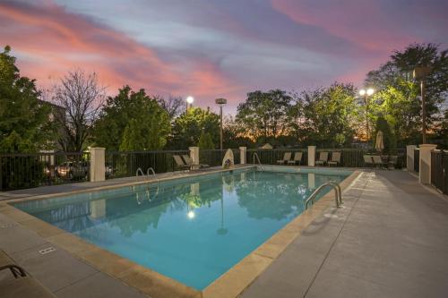 a swimming pool with a sunset in the background at Best Western Suites near Opryland in Nashville