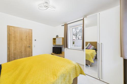 a bedroom with a yellow bed and a window at Attraktive Neubauwohnung in Bremen
