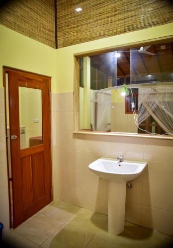 a bathroom with a sink and a mirror at Hotel Finlanka in Hikkaduwa
