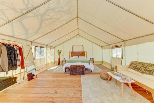 a bedroom in a tent with a bed and a couch at Hill Country Escape Glamping Tent in Boerne
