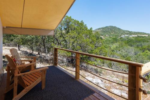 a deck with a chair and a view of the ocean at Stargazer Hill Country Glamping Tent in Boerne