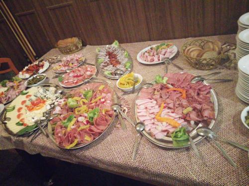 una mesa con muchos platos de diferentes tipos de comida en Horská chata Roubenka, en Strážné