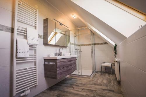 um banheiro com uma pia, um chuveiro e um espelho em Gesundheitsbauernhof -Landhof - Offenbacher em Seckau