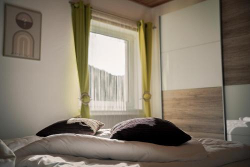a bed with two pillows in front of a mirror at Gesundheitsbauernhof -Landhof - Offenbacher in Seckau