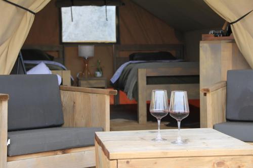 two wine glasses sitting on a table in a tent at Boutique Safari Tent Near SpaceX Launch Site in Colonia Acres
