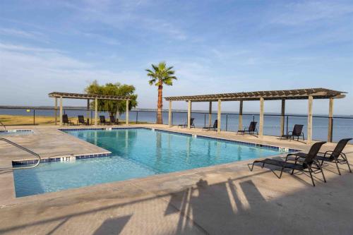 a swimming pool with chairs and a view of the ocean at A Calm and Cozy Lakeside Glamping Retreat Awaits in Onalaska